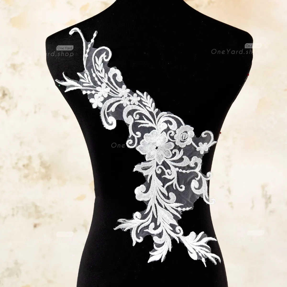 the off white lace applique features intricate abstract floral patterns